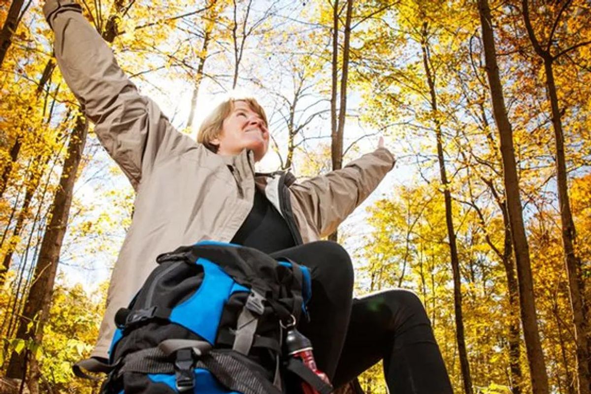 A happy middle-aged woman outside in the outdoors in the fall.