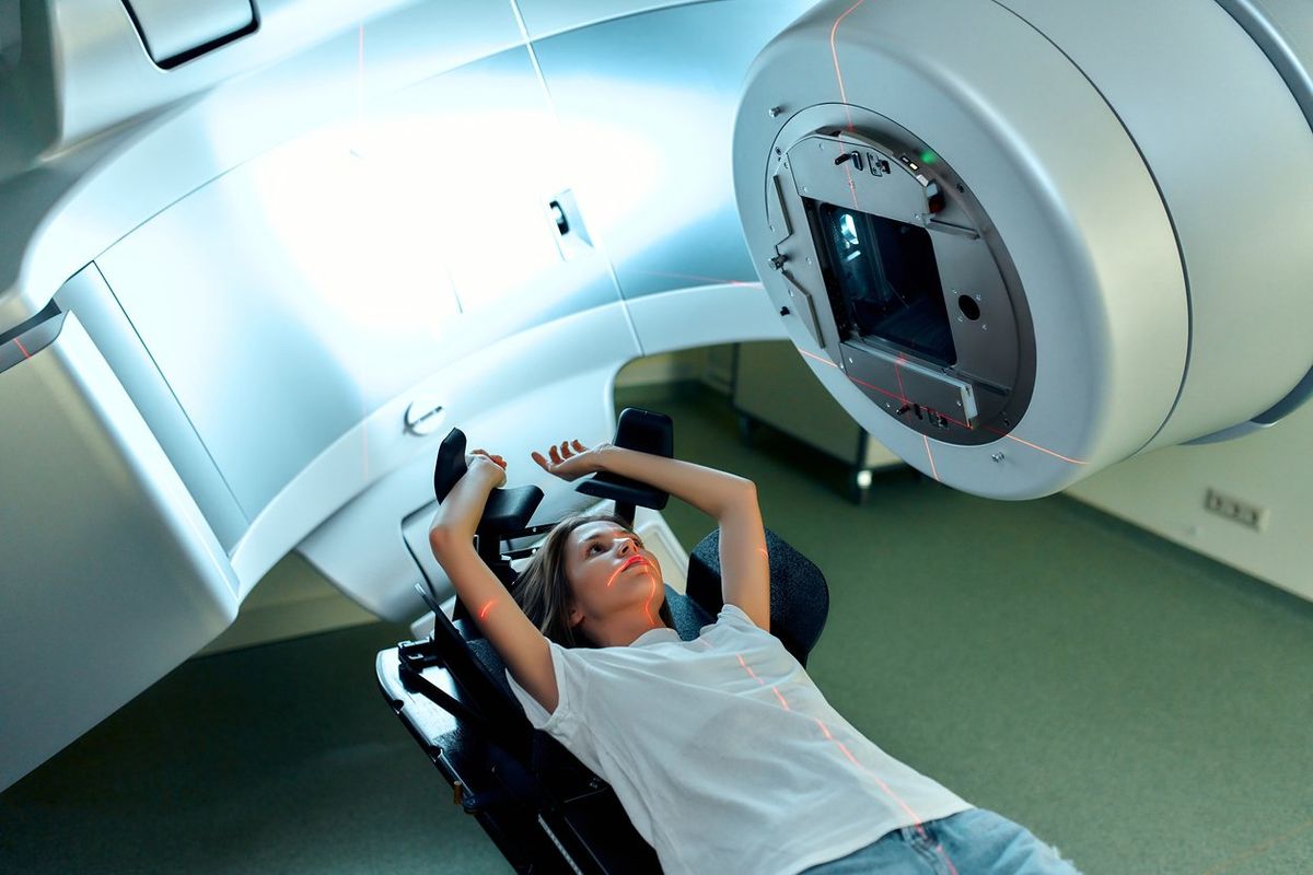 A young woman is undergoing radiation therapy for cancer in a modern cancer hospital.