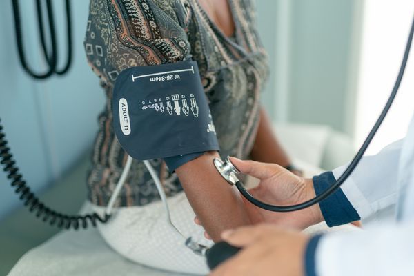 adult woman has blood pressure checked