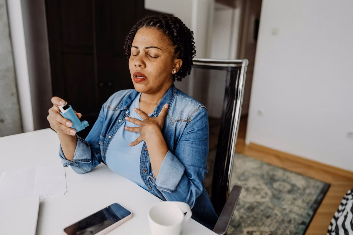adult woman using her asthma inhaler