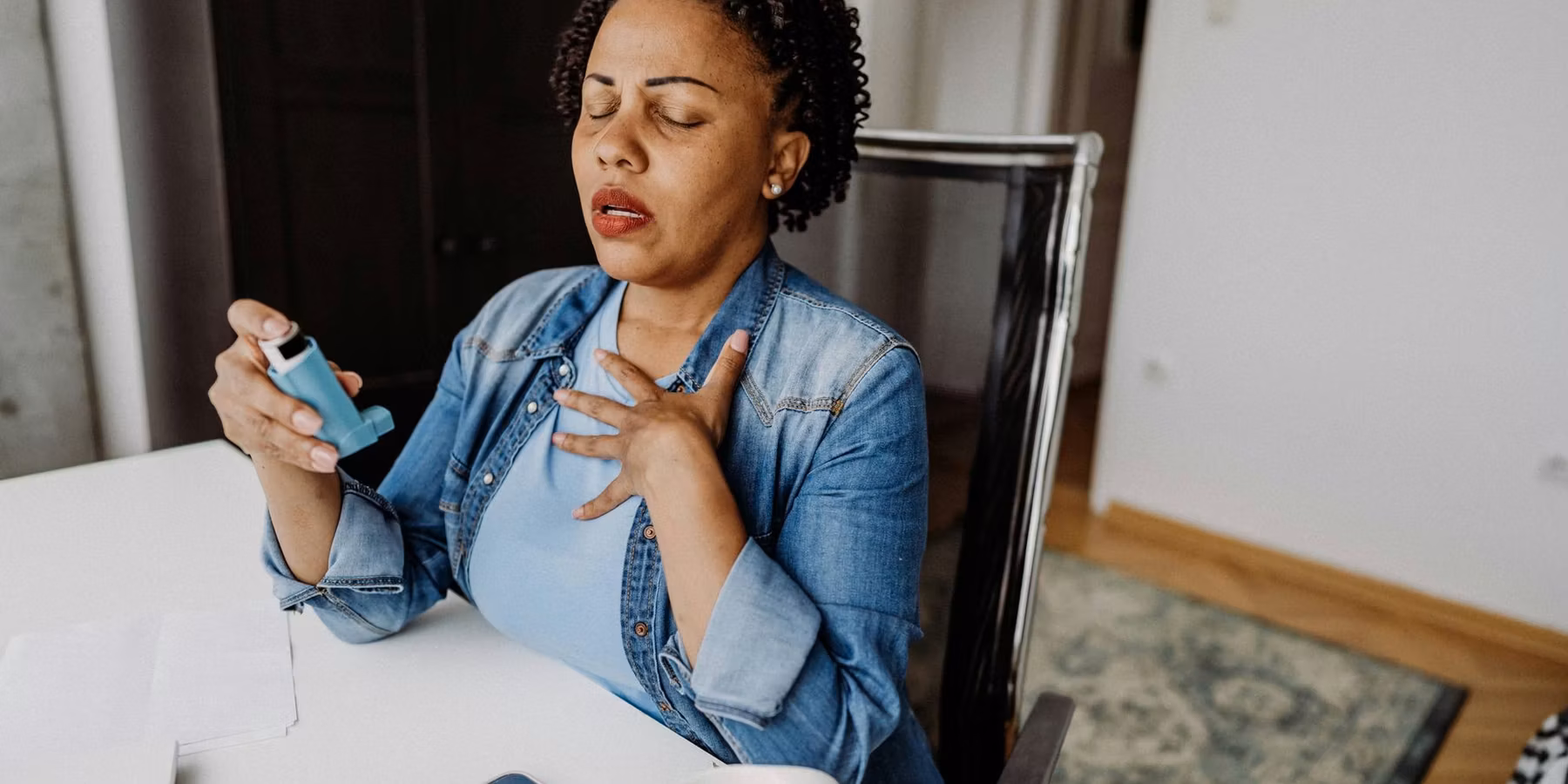 adult woman using her asthma inhaler