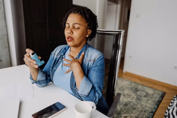adult woman using her asthma inhaler