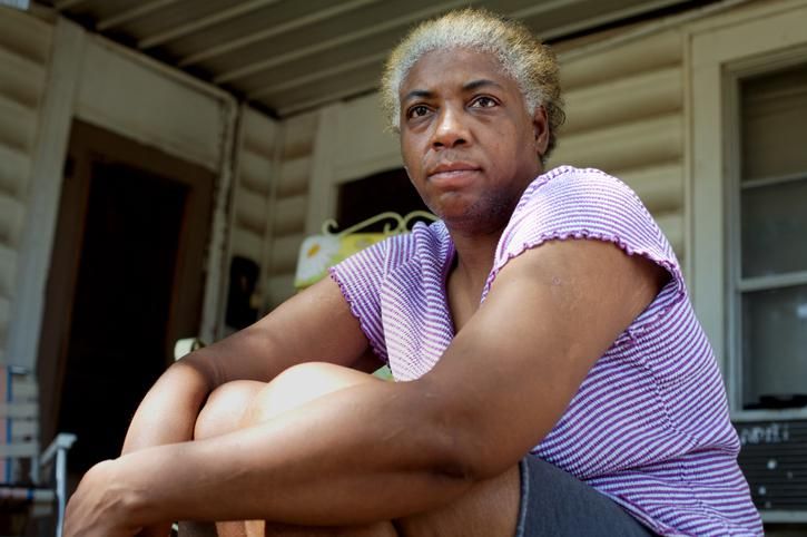 African American black woman on front porch in underprivileged part of rural small town Missouri