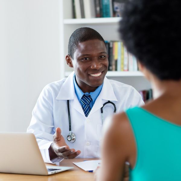 African american doctor with good news for female patient at hospital