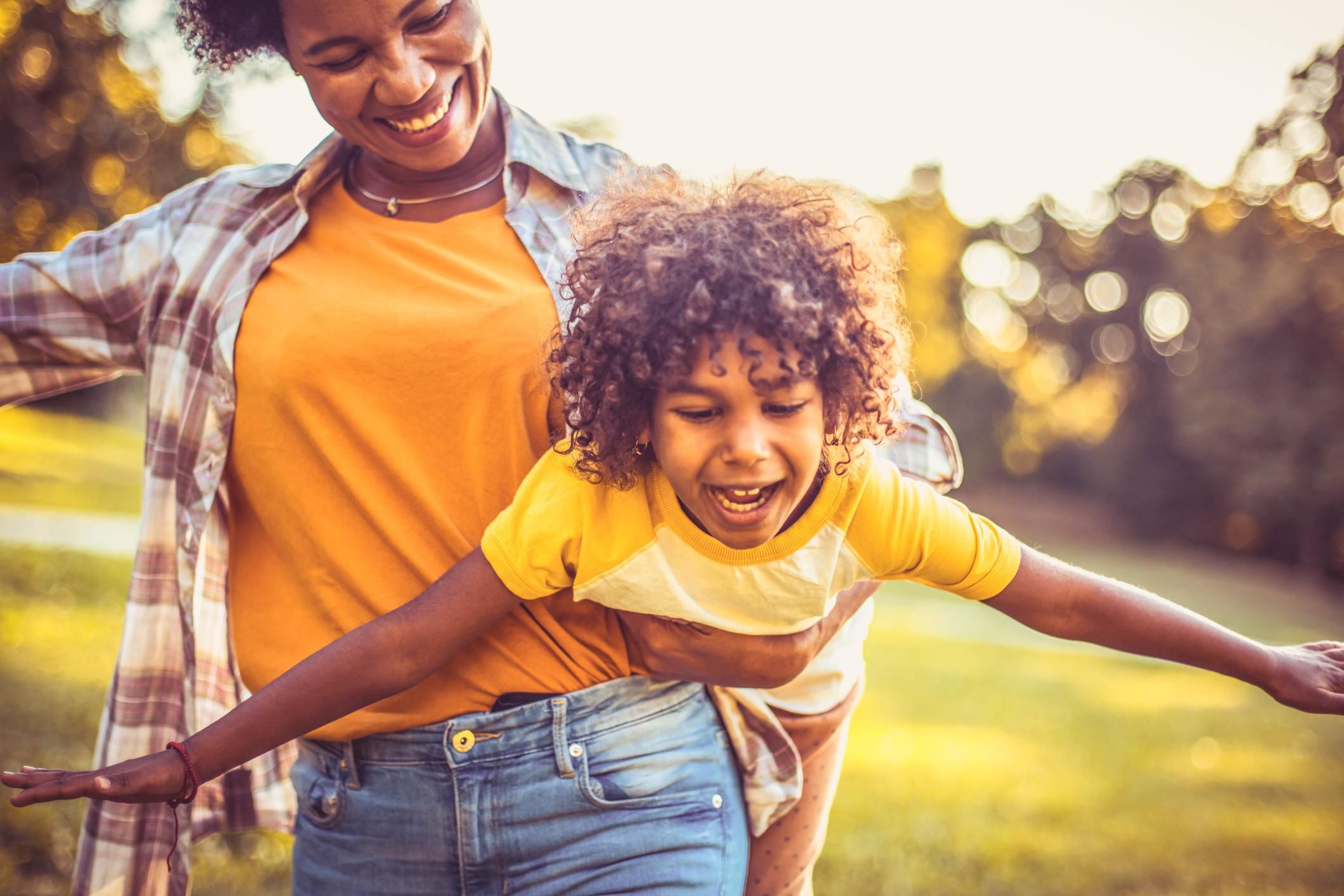 African American mother and daughter playing in the park.