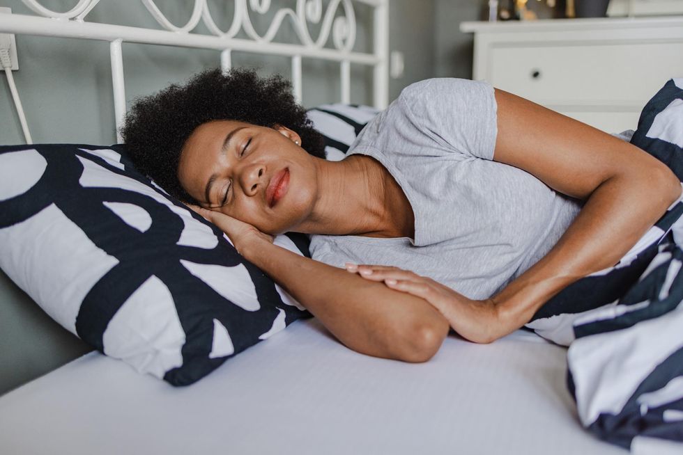 African-American woman sleeping in bed at home stock photo
