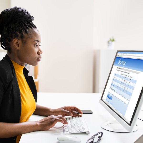 African Woman Filling Survey Poll Or Form On Desktop Computer