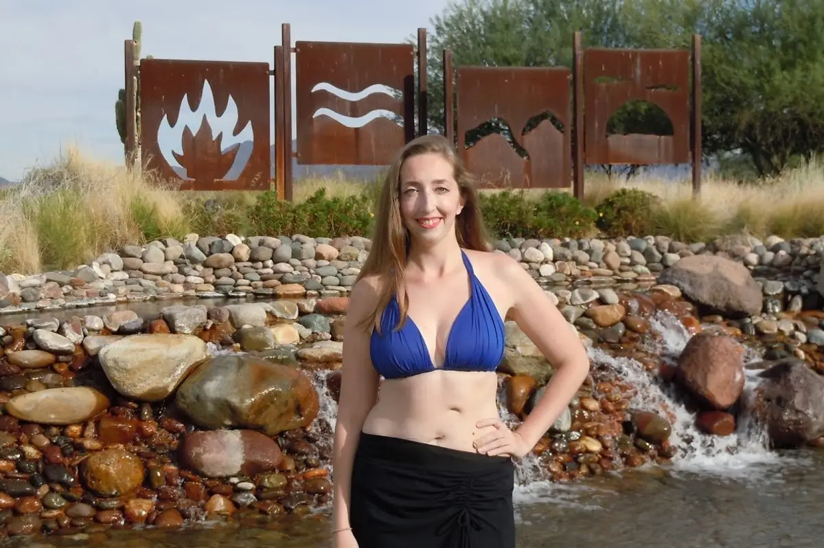 Alyssa Zeldenrust standing in a body of water, uses an Ostomy Bag Because of Crohn's Disease