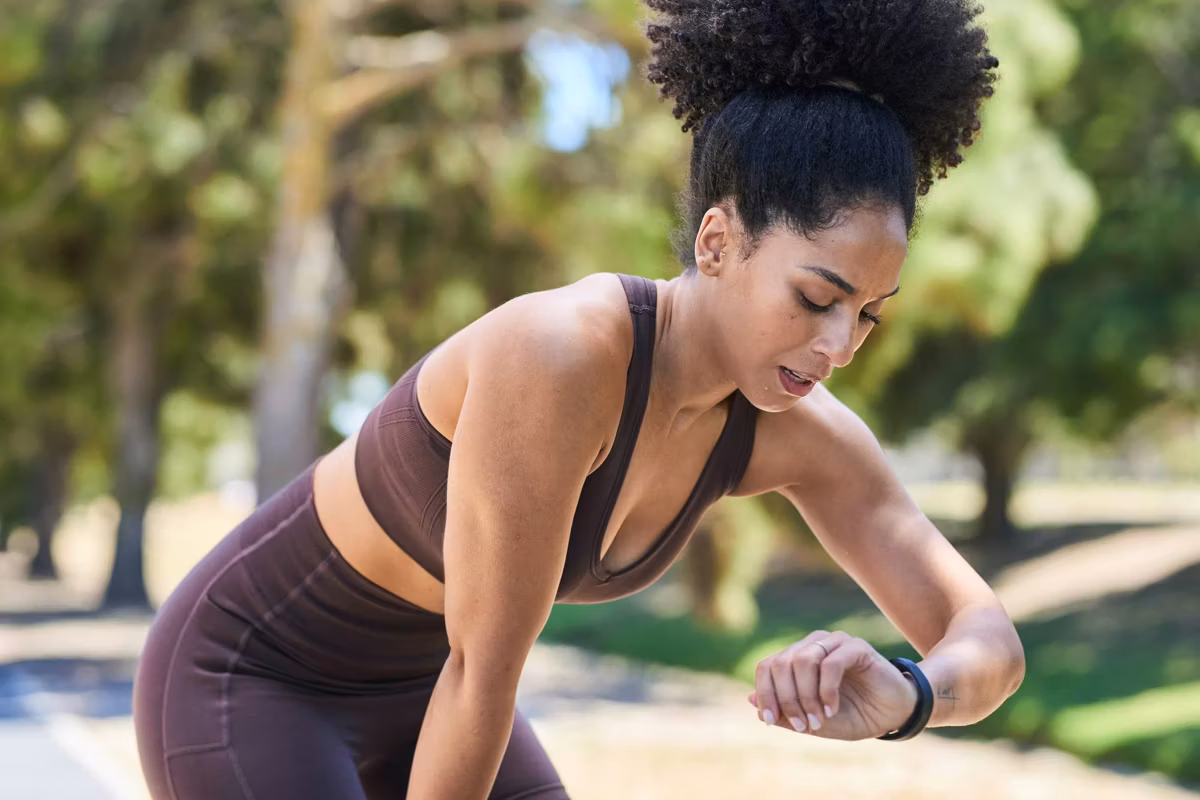 Athletic Woman On A Park Run Checks Time During Outdoor Training Session