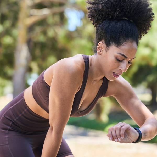Athletic Woman On A Park Run Checks Time During Outdoor Training Session