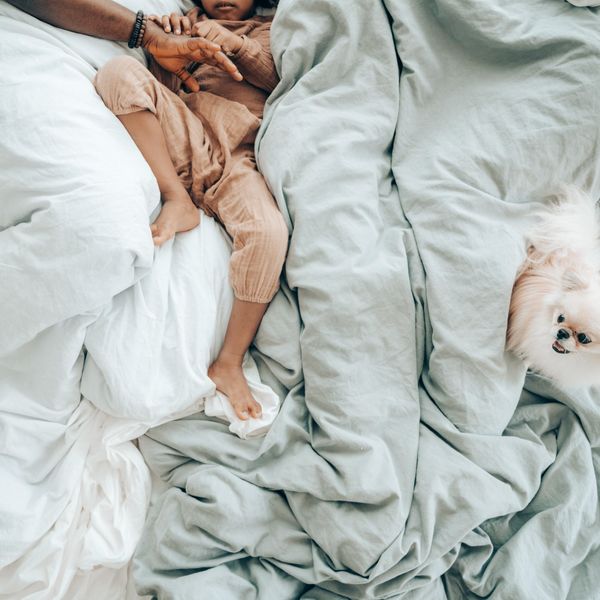 baby and dog on a down comforter