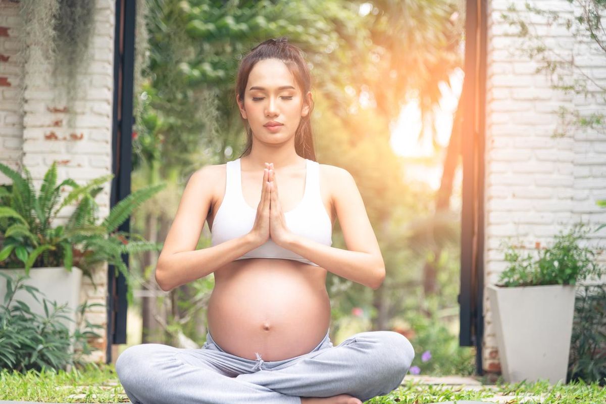 Beautiful Asian pregnant woman relaxing in the park