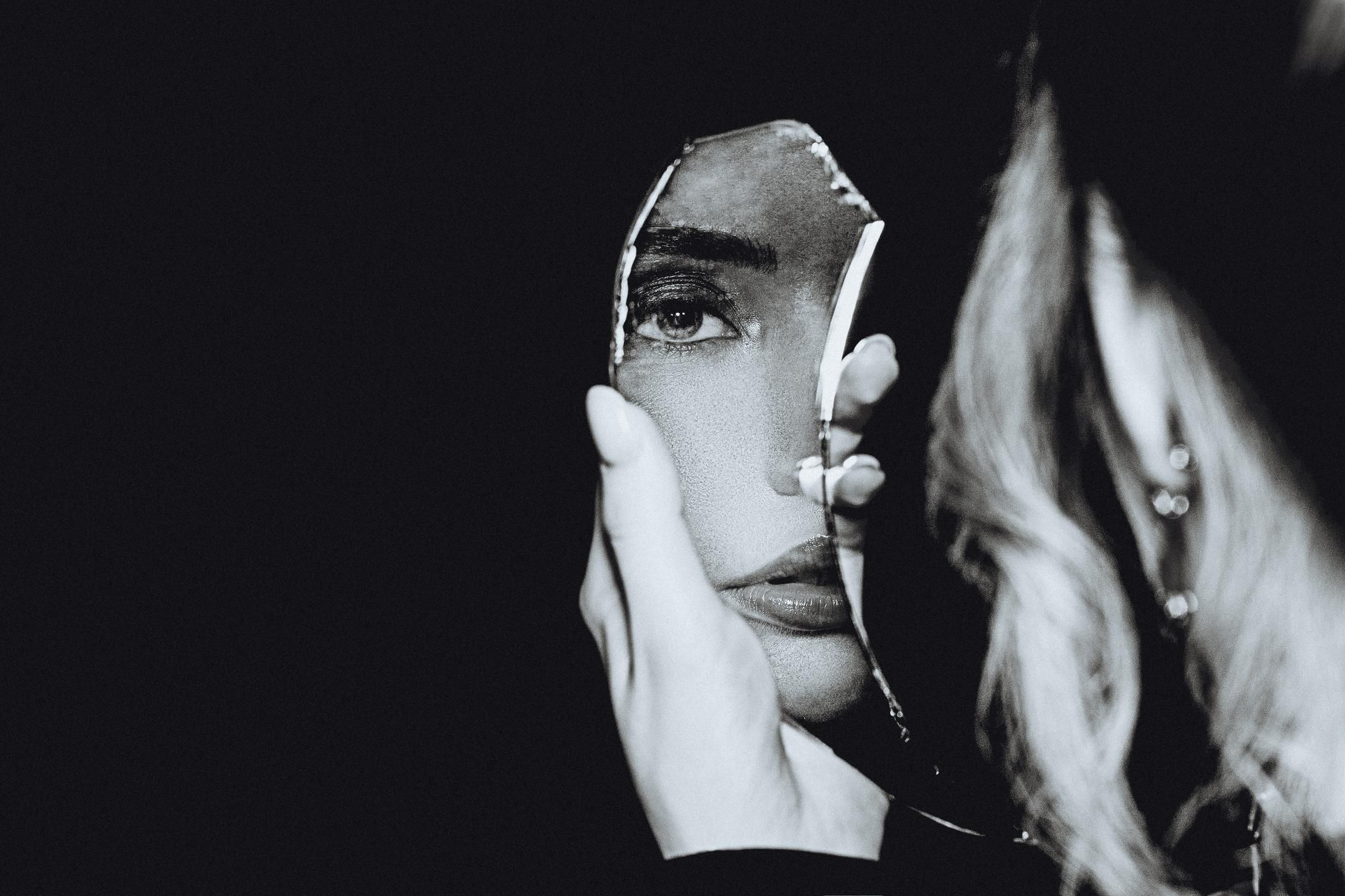 Black and white portrait of woman and broken self-image mirror