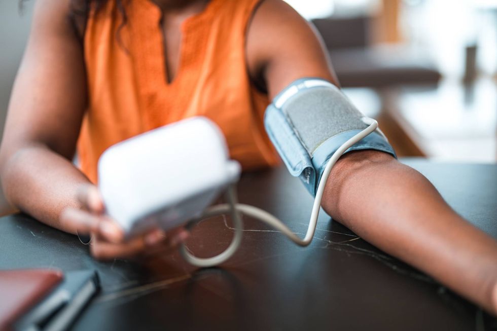 black female using a medical device for blood pressure measuring