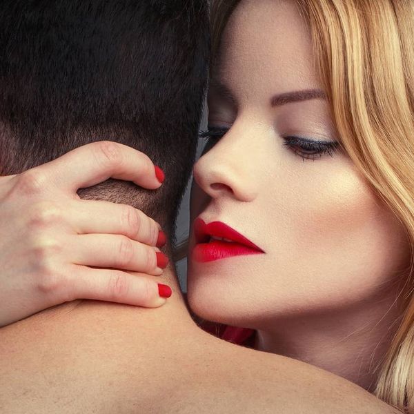 blonde woman in red lips holding man in arms at night
