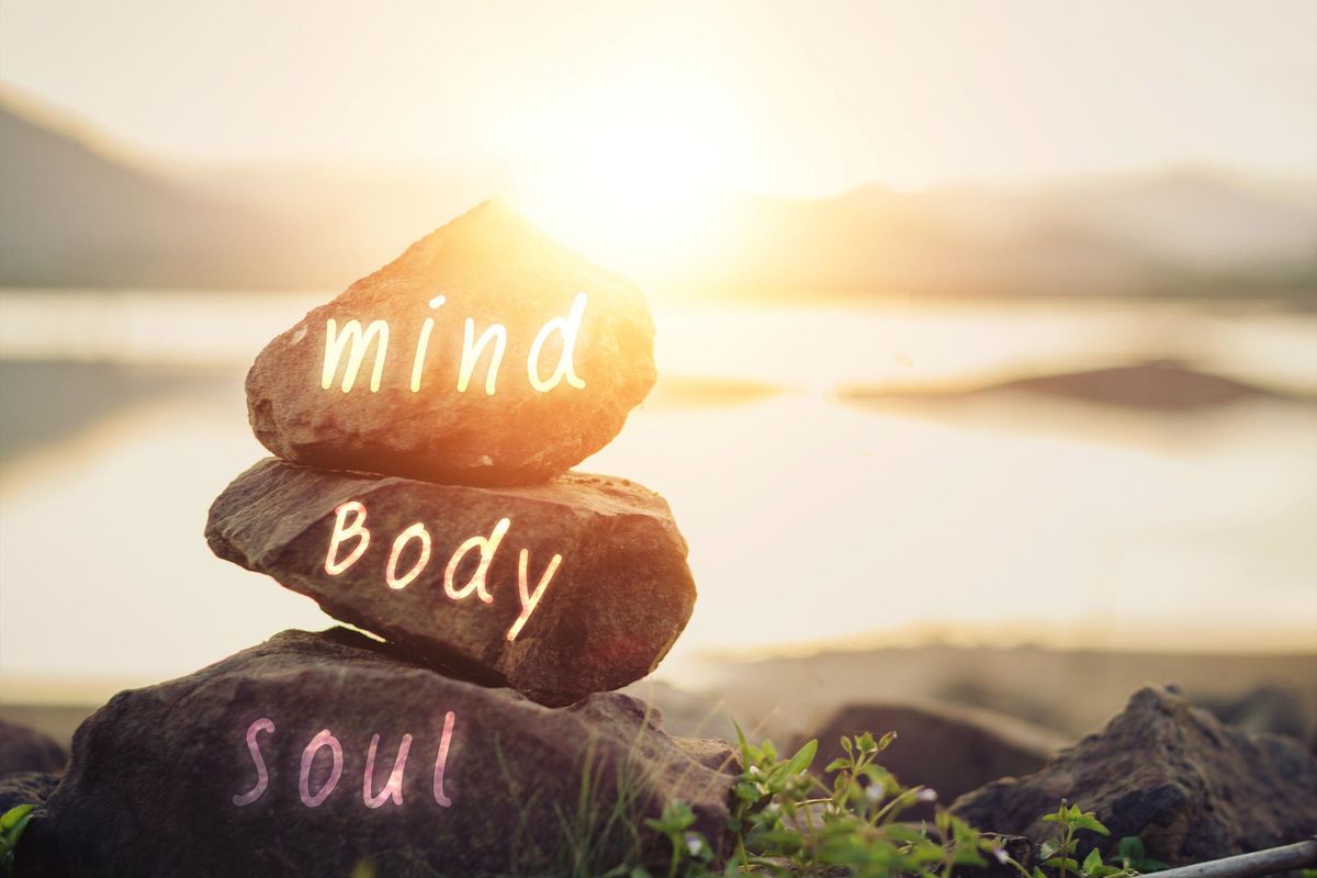 Body, mind, soul, spirit written on rocks