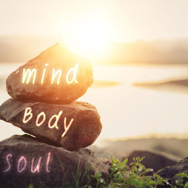 Body, mind, soul, spirit written on rocks