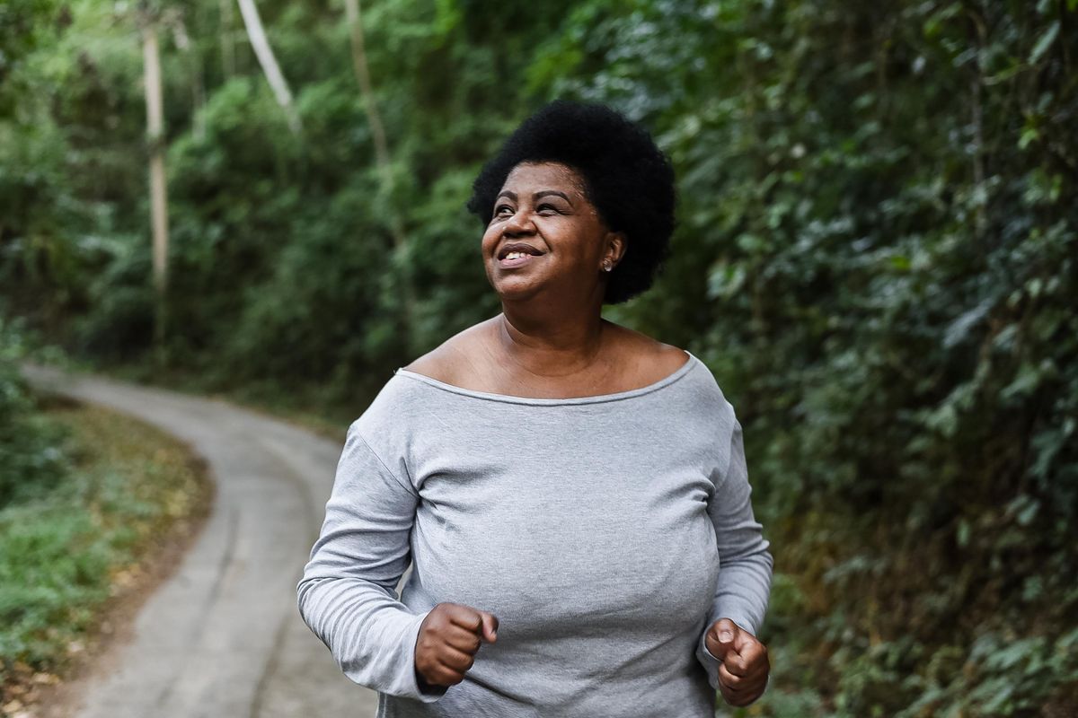 Body positive obese woman running in nature park