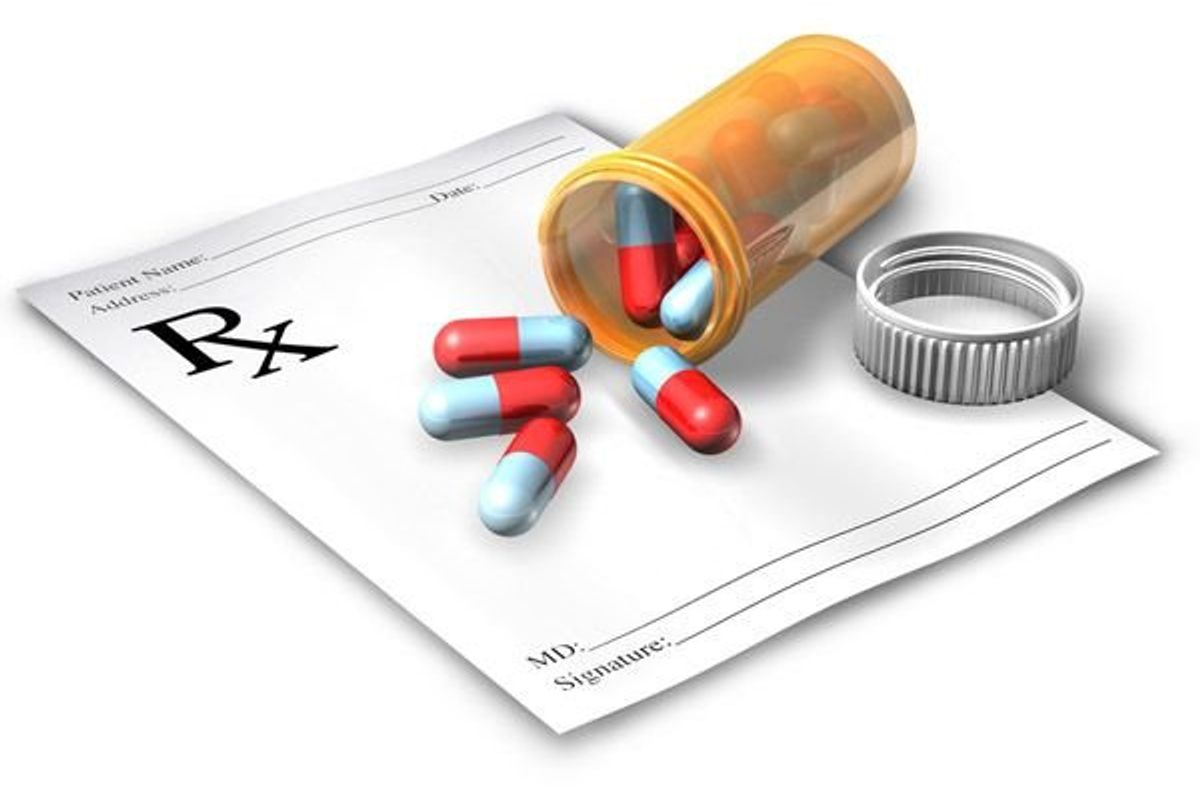 bottle of prescription medication on its side with the pills spilling out