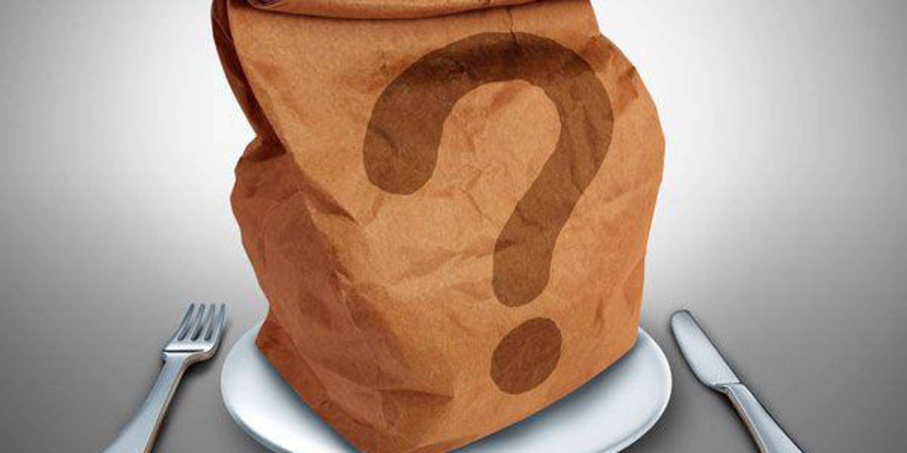 brown paper bag with a question mark on a plate