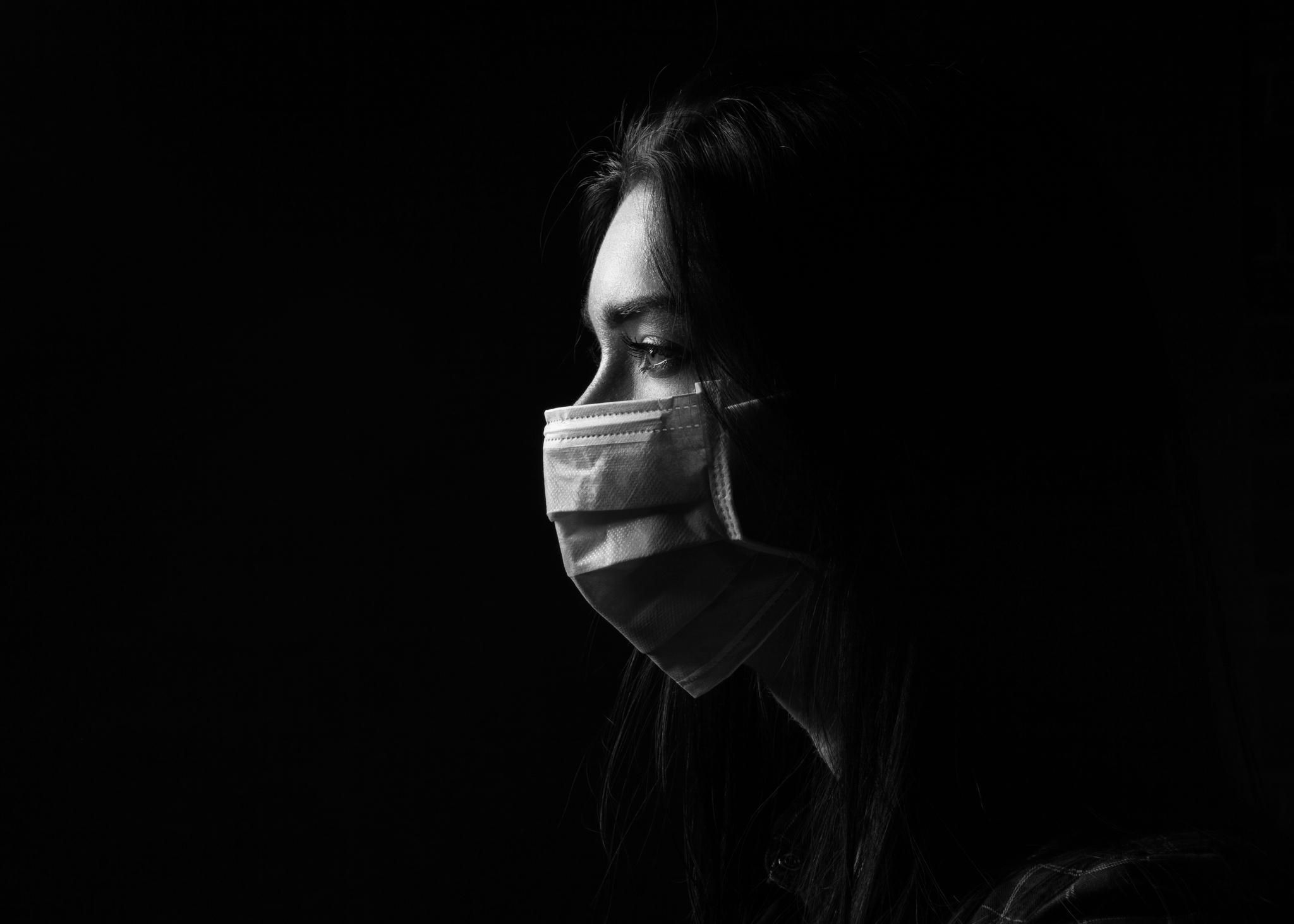 brunette girl in a protective mask on a black background
