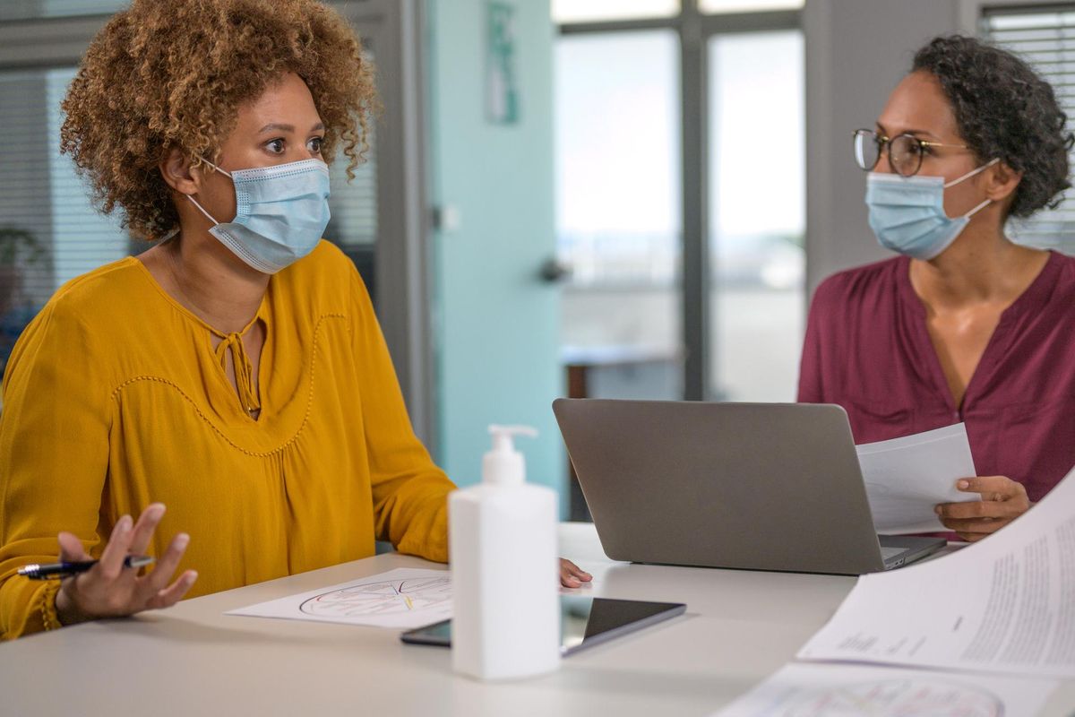 Business people wearing protective face masks at work