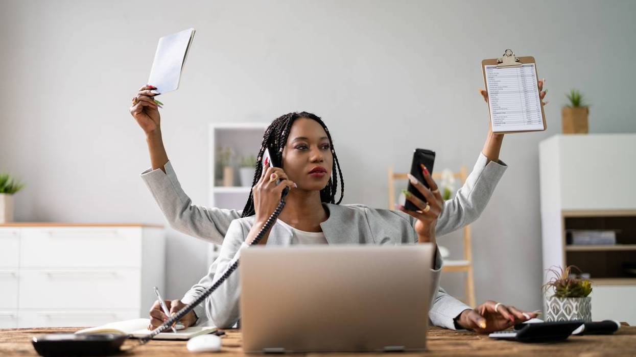 Businesswoman Doing Multitasking Work At Workplace