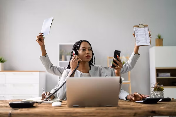Businesswoman Doing Multitasking Work At Workplace