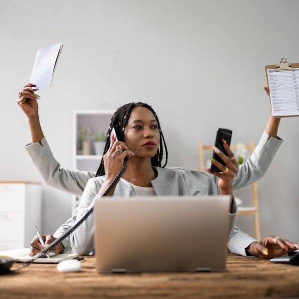 Businesswoman Doing Multitasking Work At Workplace