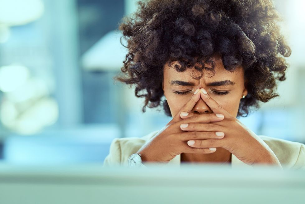 businesswoman experiencing a migraine while working at her desk