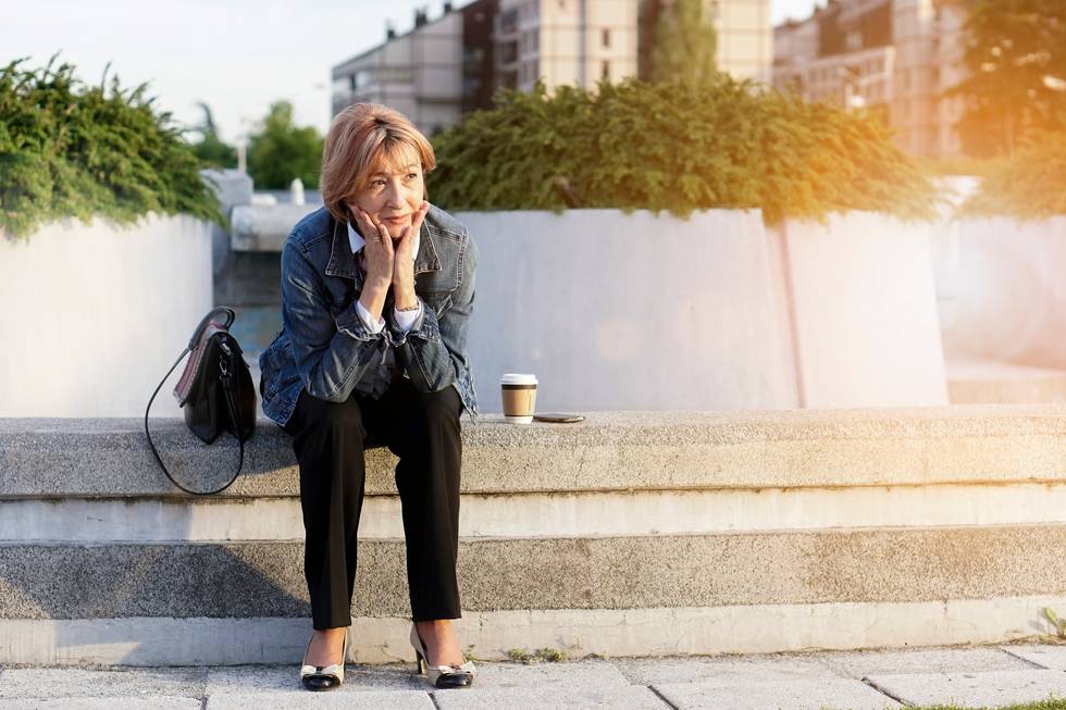 Businesswoman sitting with hand in her chin and looking away worry about Vitamin B12 Deficiency
