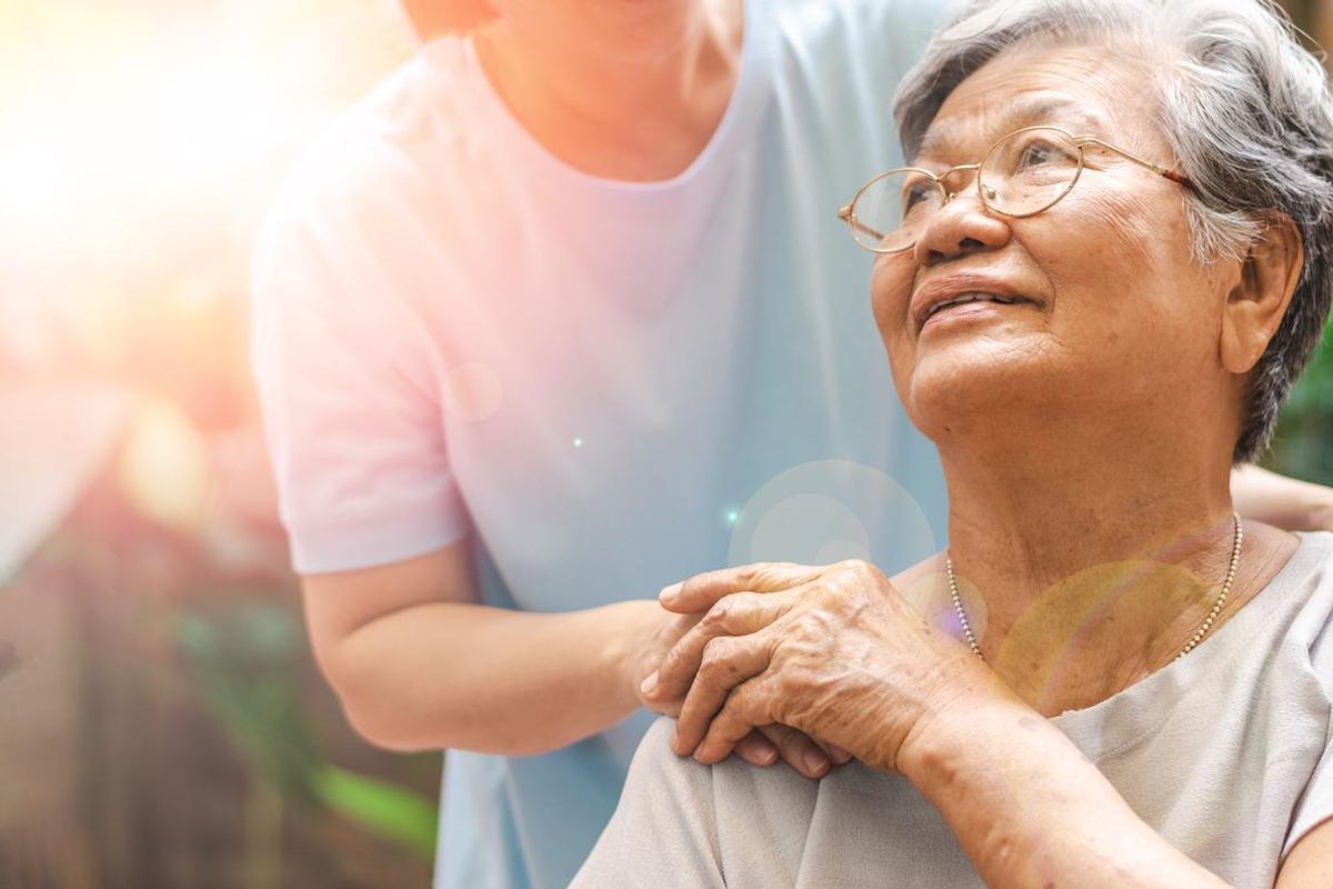 Caregiver, carer hand holding elder hand in hospice care