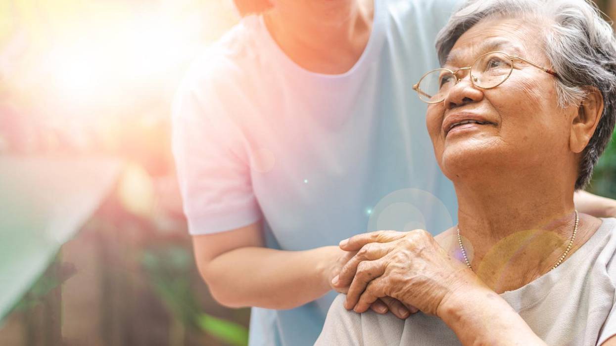 Caregiver, carer hand holding elder hand in hospice care