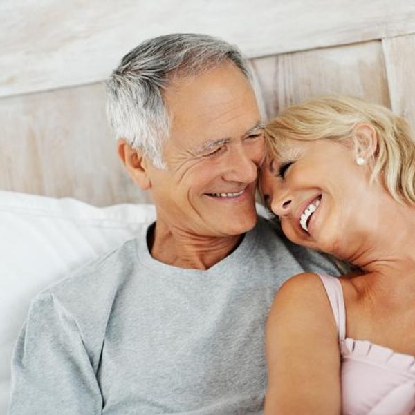 Cheerful senior woman resting on mature man's shoulder
