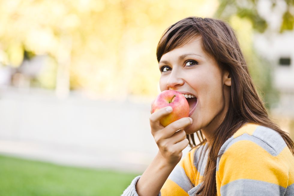 cheerful woman eating an apple for weight loss