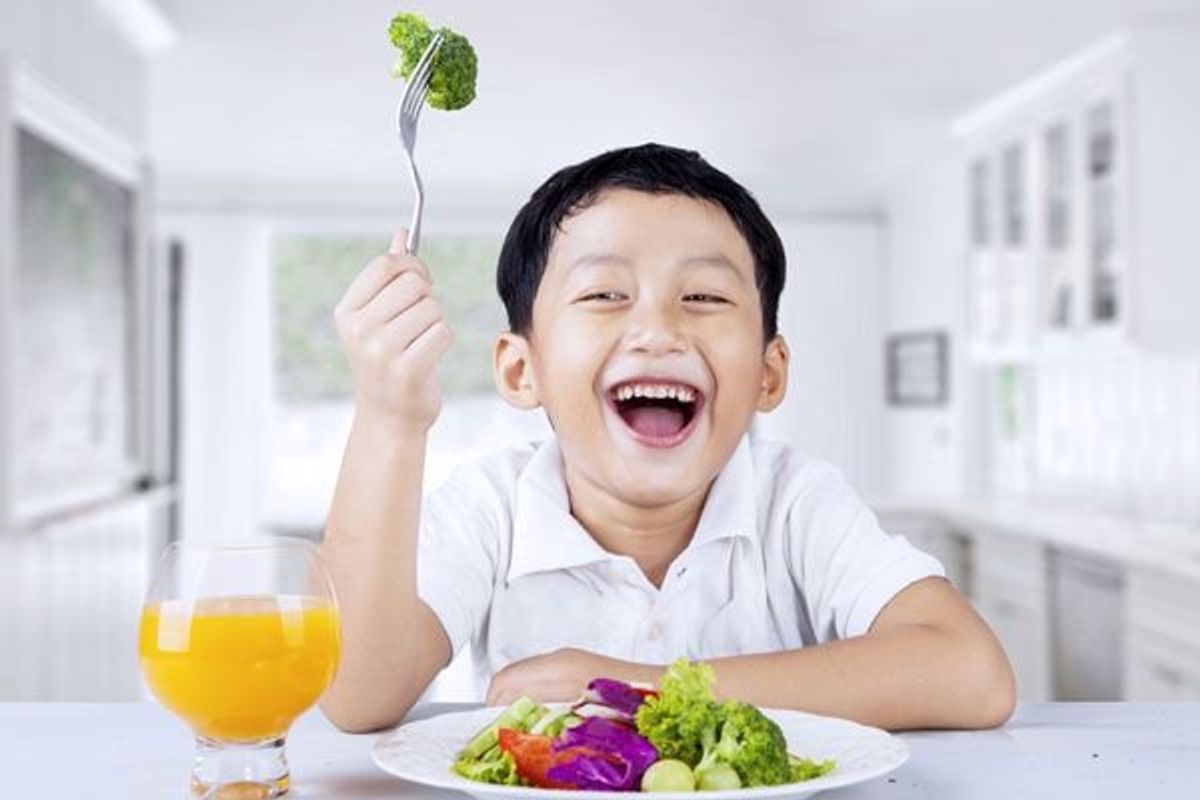 child eating a plate of vegetables