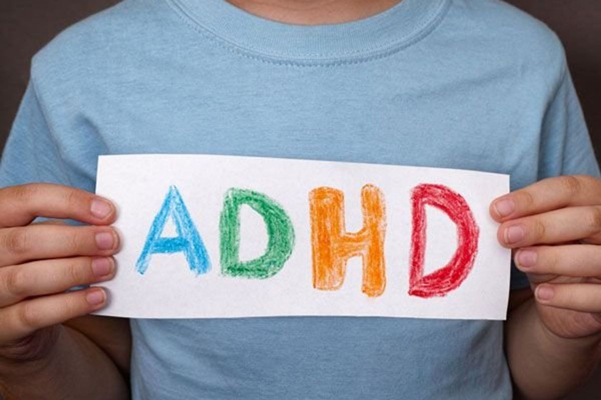 child holding a sign that says ADHD