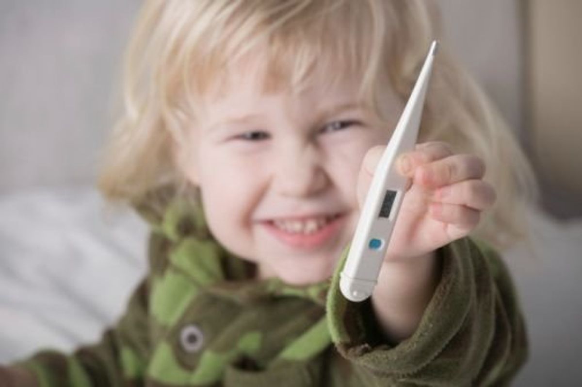 child holding a thermometer
