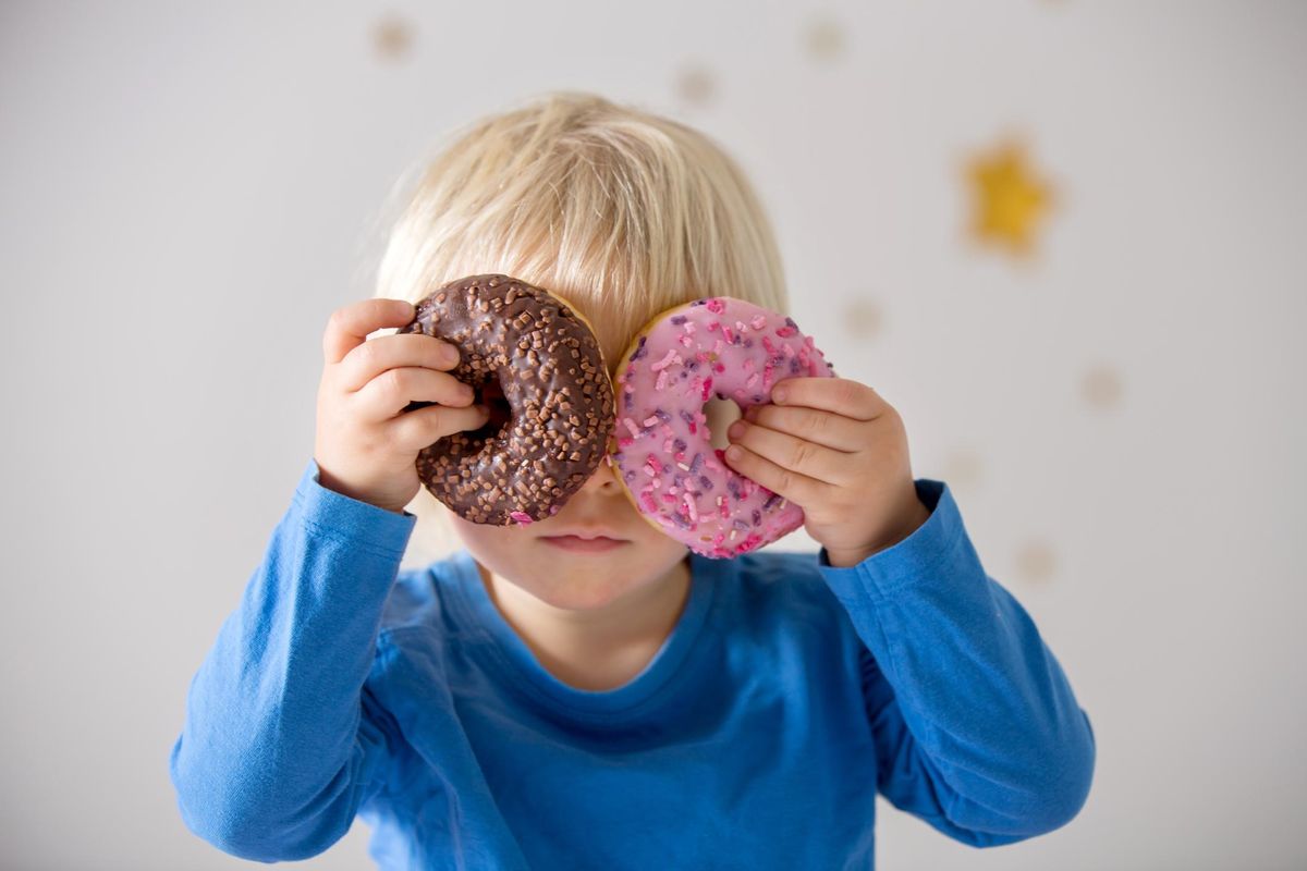 child playing and eating donuts