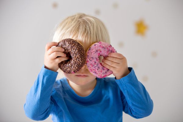 child playing and eating donuts