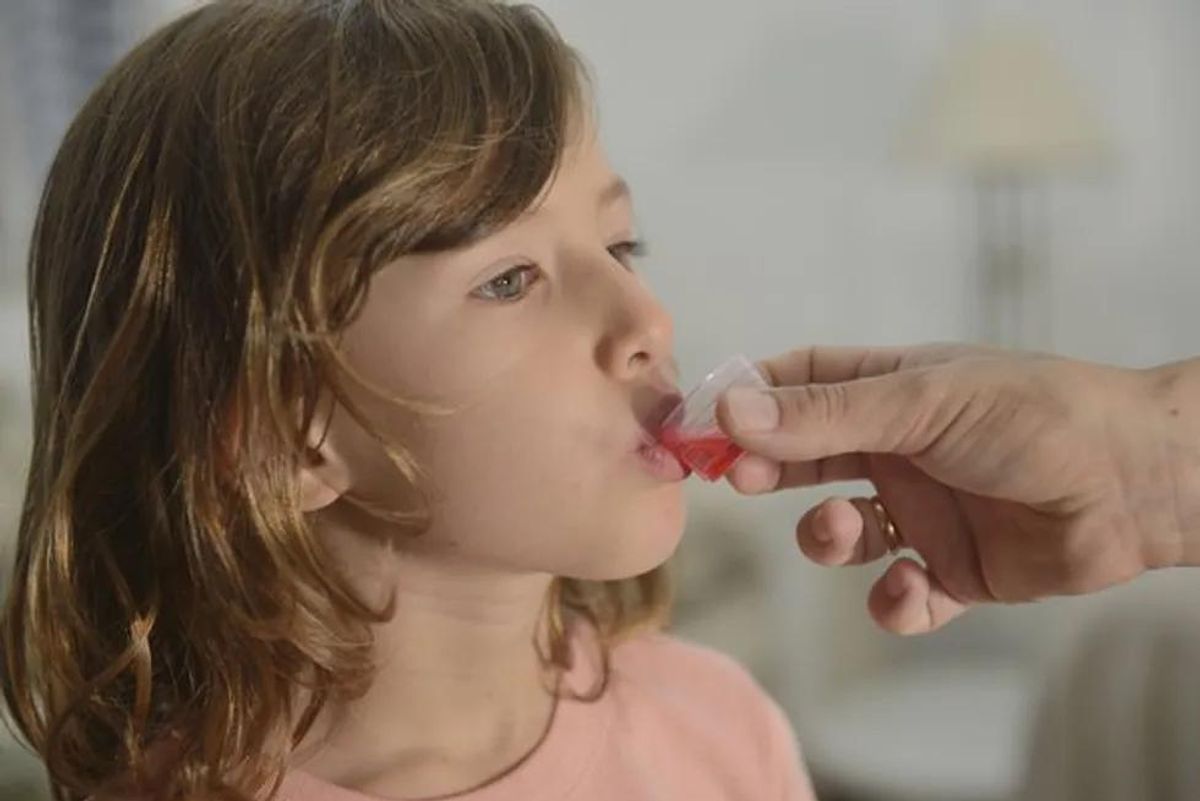 child taking cough syrup