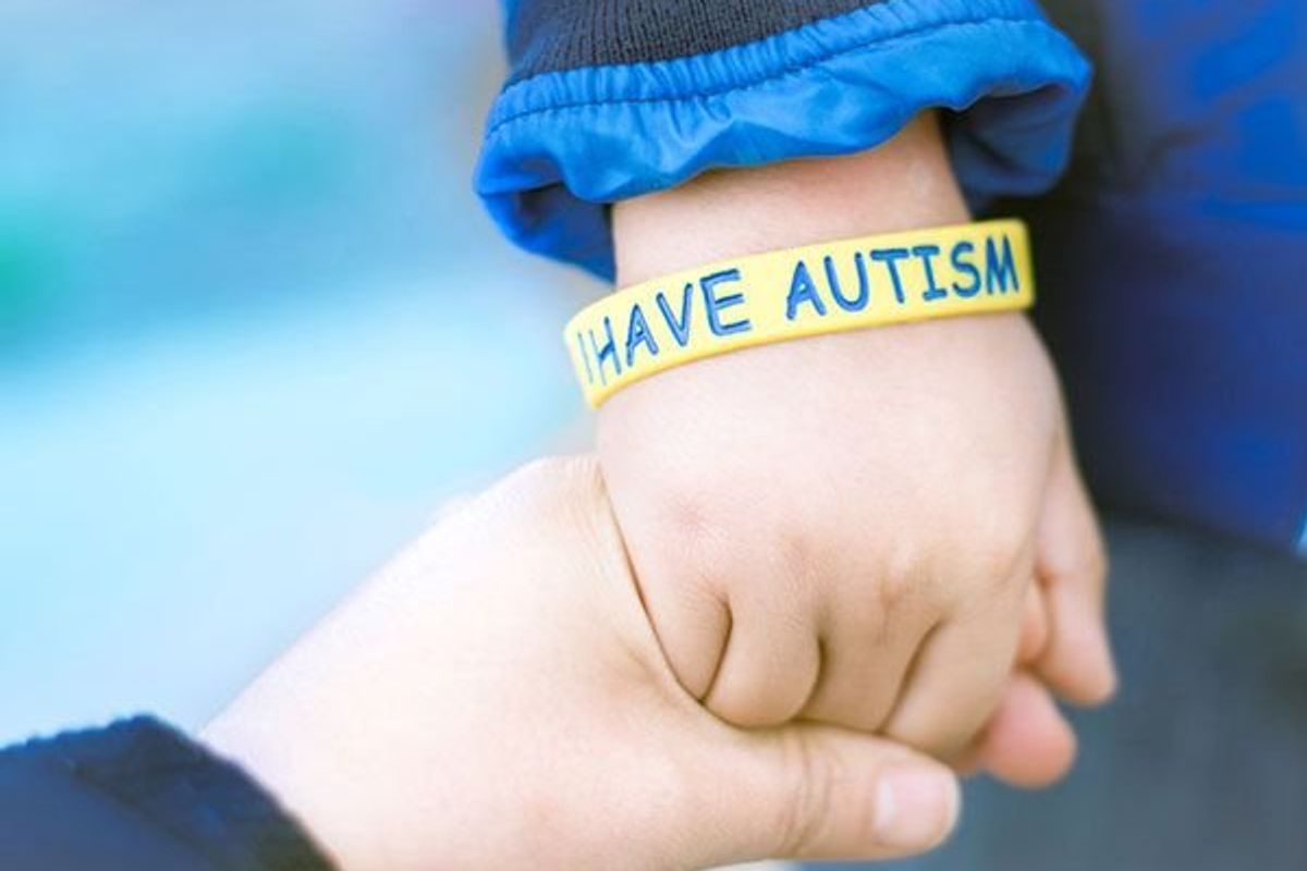 child wearing an autism awareness bracelet