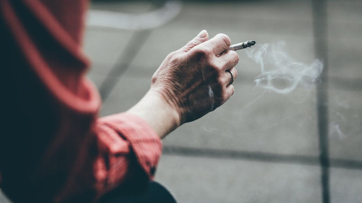 close up of a hand holding a cigarette