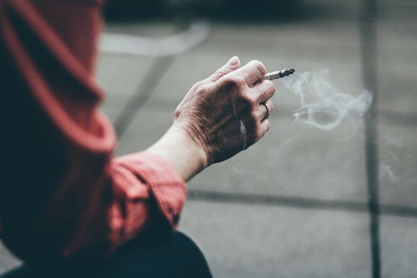 close up of a hand holding a cigarette