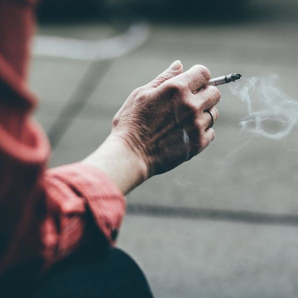 close up of a hand holding a cigarette