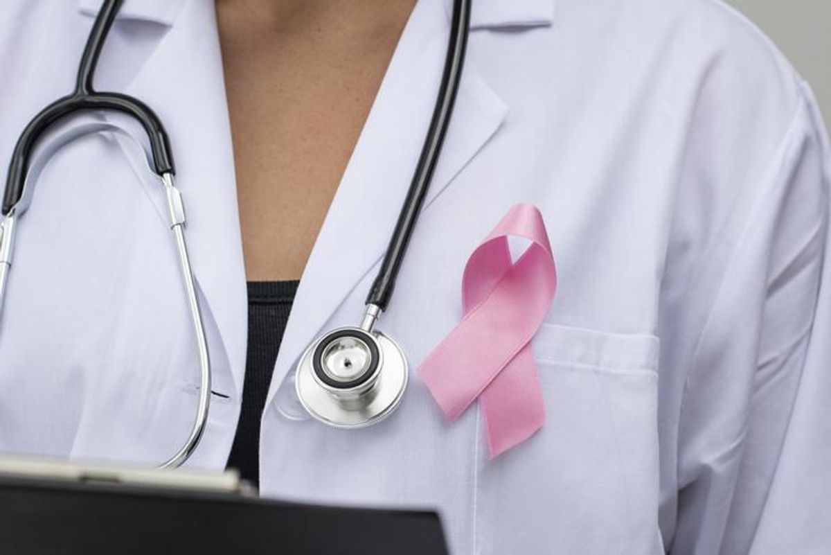 Close-up of Doctor with ribbon formed breast cancer awareness symbol