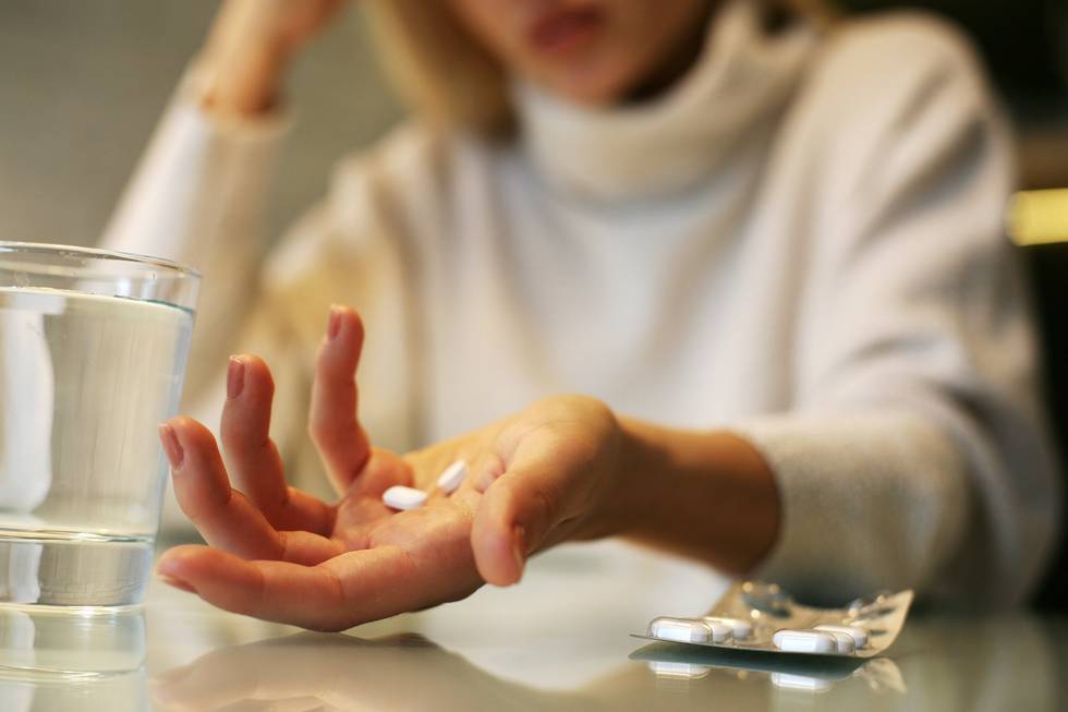 Close up of woman hands holding a pills.