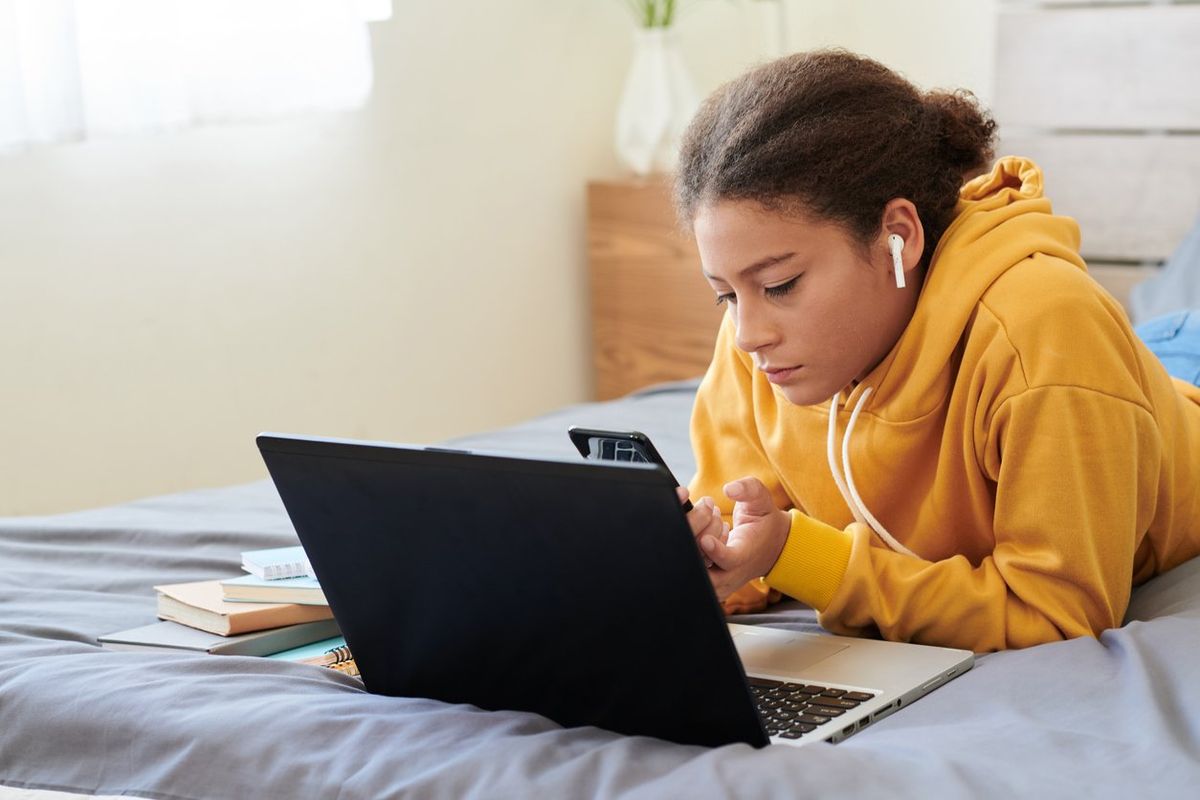 college girl on her laptop in bed