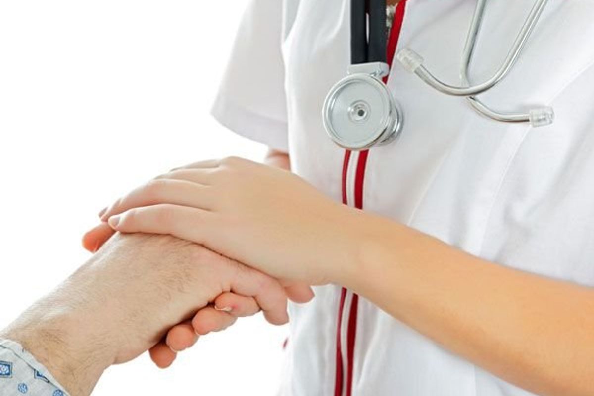 compasstionate nurse holding patient's hand