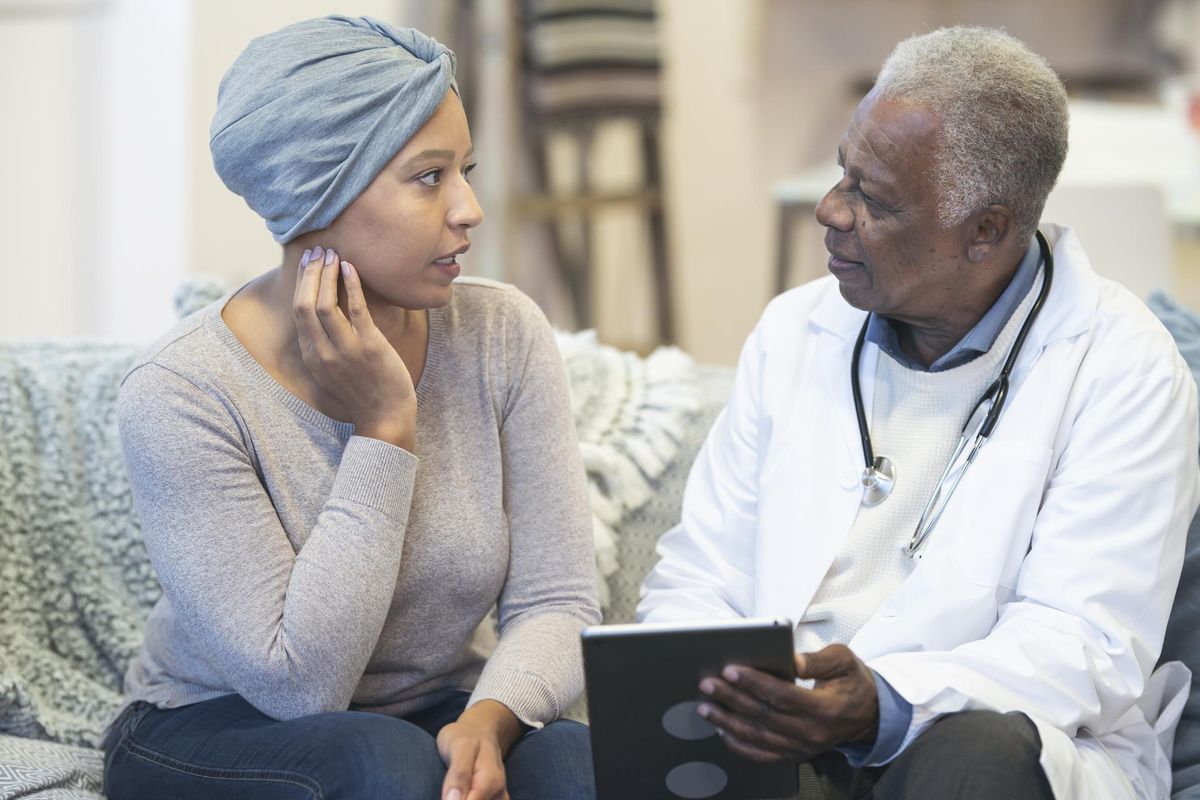 Concerned woman with cancer consulting doctor